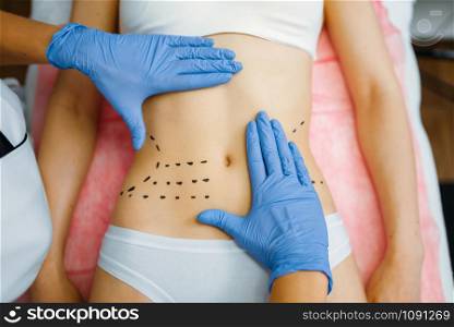 Cosmetician&rsquo;s hands on female patient abdomen, botox therapy preparation. Rejuvenation procedure in beautician salon. Cosmetic surgery against wrinkles and aging