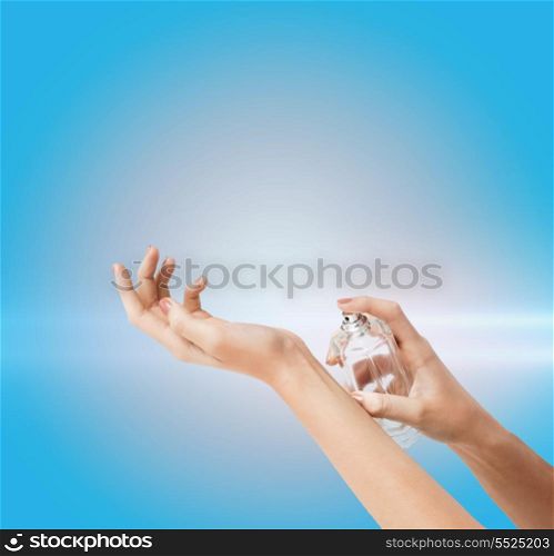 cosmetics, body parts and beauty concept - close up of woman hands spraying perfume