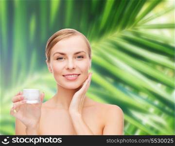 cosmetics, health and beauty concept - beautiful woman applying cream on her skin