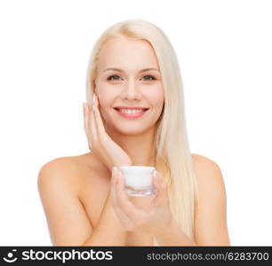 cosmetics, health and beauty concept - beautiful woman applying cream on her skin