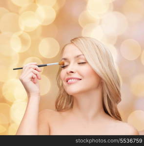 cosmetics, health and beauty concept - beautiful woman with closed eyes and makeup brush