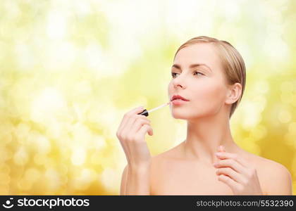 cosmetics, health and beauty concept - beautiful woman with pink lipgloss