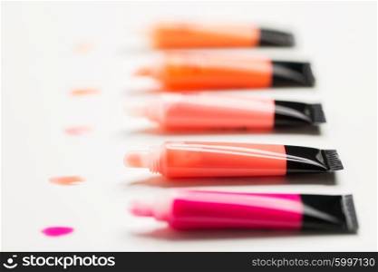 cosmetics, make up and beauty concept - close up of lip gloss tubes