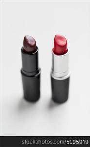 cosmetics, makeup and beauty concept - close up of two open lipsticks