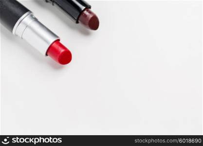cosmetics, makeup and beauty concept - close up of two open lipsticks