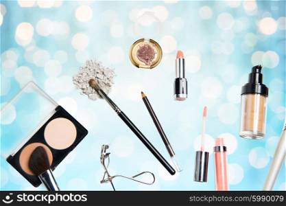 cosmetics, makeup, holidays and beauty concept - close up of makeup stuff over blue lights background