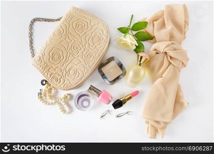 Cosmetics, perfumes, jewelry made of pearls and handbag on a white background. Flat lay, top view.