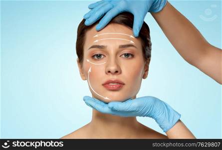 cosmetology, plastic surgery and beauty concept - beautiful young woman face and hands in surgical gloves over blue background. beautiful young woman face and hand in gloves