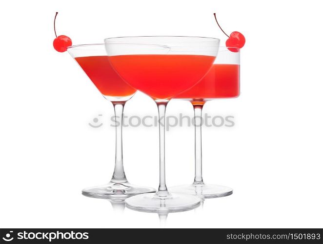Cosmopolitan cocktail in classic crystal glasses with pink cherry on white background.