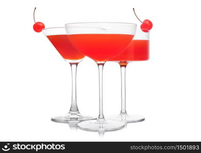 Cosmopolitan cocktail in classic crystal glasses with pink cherry on white background.
