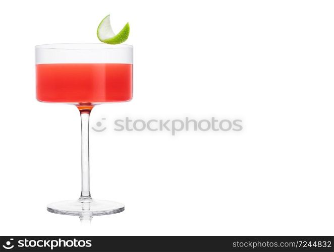 Cosmopolitan cocktail in modern crystal glass with lime peel on white background. Space for text