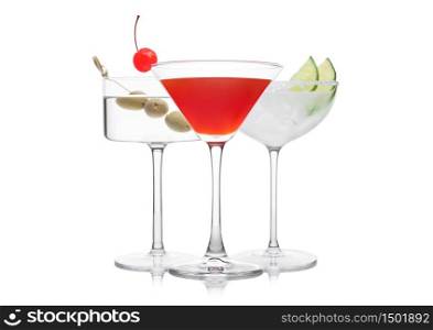 Cosmopolitan, Vodka Martini and Margarita cocktails in classic crystal glasses with pink cherry, limes and olives on white background.