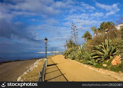 Costa del Sol promenade along the Mediterranean Sea from Marbella to Puerto Banus (visible on the horizon) in Spain, Malaga province, Andalucia