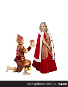 Costume Series: Little Boy Dressing Like a Clown Standing on his Knee and Giving a Present to the Beautiful Little Blond Girl Wearing a Costume of a Queen.