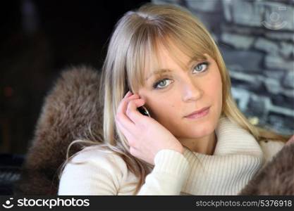 Cosy blond woman making a call from home