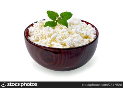 Cottage cheese in a wooden bowl with mint isolated on white background