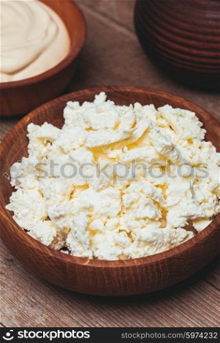 cottage cheese or curd in a wooden bowl. The cottage cheese