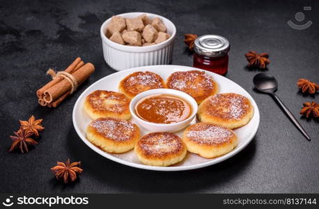 Cottage cheese pancakes on a black concrete background. Cottage cheese pancakes with oats, syrniki on a black rustic background