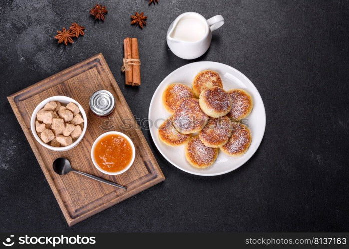 Cottage cheese pancakes on a black concrete background. Cottage cheese pancakes with oats, syrniki on a black rustic background