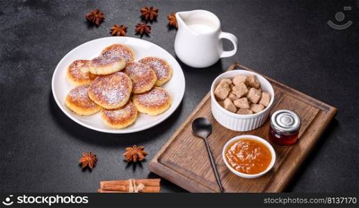 Cottage cheese pancakes on a black concrete background. Cottage cheese pancakes with oats, syrniki on a black rustic background