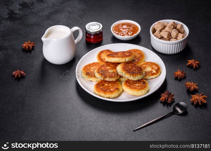 Cottage cheese pancakes on a black concrete background. Cottage cheese pancakes with oats, syrniki on a black rustic background