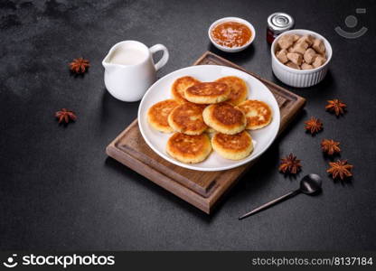 Cottage cheese pancakes on a black concrete background. Cottage cheese pancakes with oats, syrniki on a black rustic background