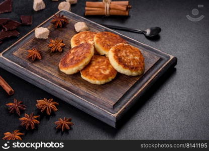 Cottage cheese pancakes, syrniki, ricotta fritters on a wooden cutting board. Homemade useful pastries. Cottage cheese pancakes, syrniki, ricotta fritters on a wooden cutting board