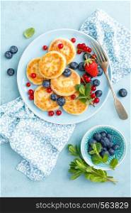 Cottage cheese pancakes, syrniki with fresh berries for breakfast