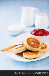 Cottage cheese pancakes with currant jam and sour cream, selective focus