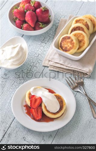 Cottage cheese patties with whipped cream and berry syrup