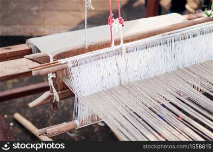 Cotton weaving loom with natural coloured threads local Thai cotton fabric making industry in rural area