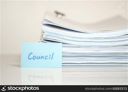 Council; Stack of Documents on white desk and Background.