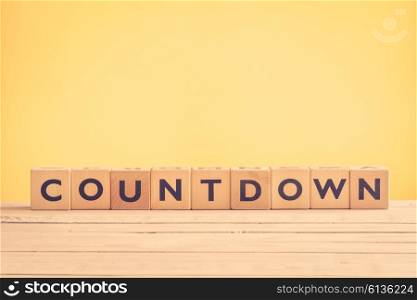 Countdown sign with wooden blocks on yellow background
