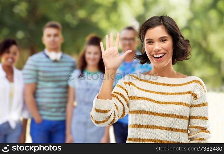 counting and people concept - happy smiling young woman in striped pullover showing five fingers of one hand over grey background. happy smiling woman showing five fingers