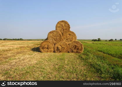 Country landscape, pasture with stack of hay bales, sunny summer day