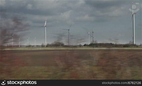 Country landscape view with windmills from moving train, Austria