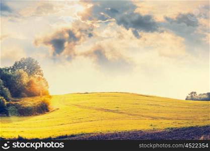 Country Landscape with hills , field , trees and beautiful sky with clouds and sunlight