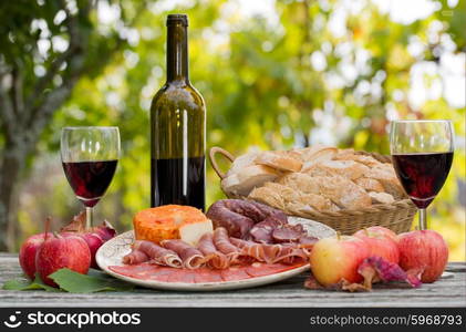 Country life setting with wine, fruits, cheese and meat. Outdoor