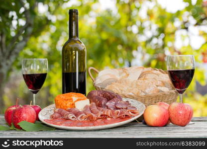 Country life setting with wine, fruits, cheese and meat. Outdoor