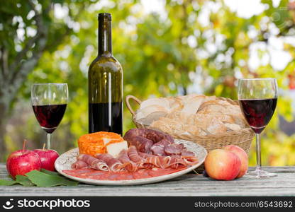 Country life setting with wine, fruits, cheese and meat. Outdoor. food set