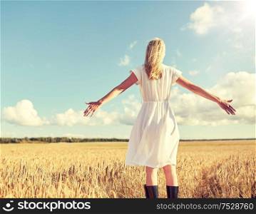 country, nature, summer holidays, vacation and people concept - happy young woman in white dress on cereal field. happy young woman in white dress on cereal field