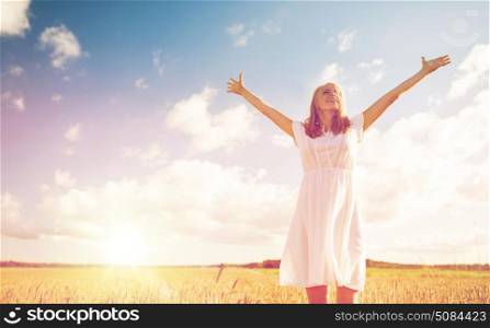 country, nature, summer holidays, vacation and people concept - smiling young woman in white dress on cereal field. smiling young woman in white dress on cereal field. smiling young woman in white dress on cereal field
