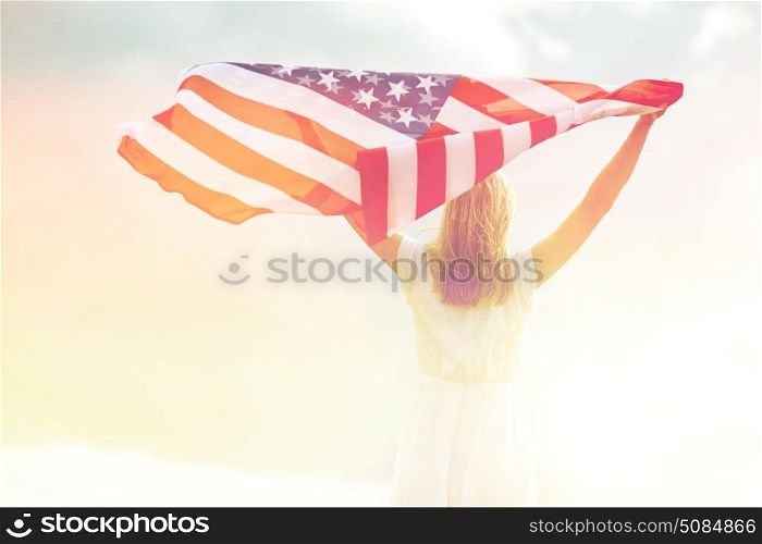 country, patriotism, independence day and people concept - happy smiling young woman in white dress with national american flag outdoors. happy young woman with american flag outdoors. happy young woman with american flag outdoors