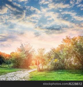 Country summer nature. Summer trees , sunflowers and lawn over beautiful sky background. Garden path.