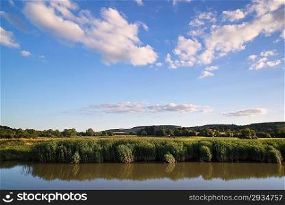 Countryside landscape blue sky reflected in calm river in Summer