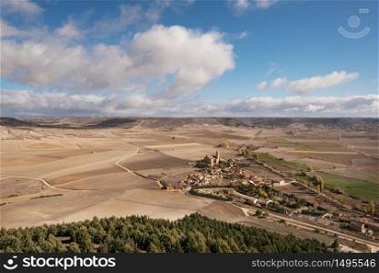 Countryside landscape in Burgos province, Castilla y Leon, Spain. Castrojeriz village is in the foreground, a blue sky and clouds over the agricultural fields.