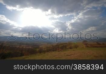 Countryside landscape, sunbeams breaking through the fast moving clouds
