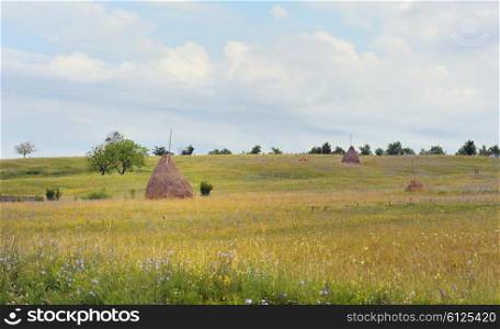Countryside landscape with haystack in summer time