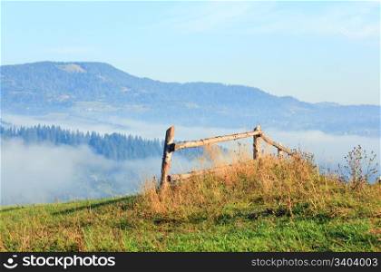 countryside landscape with wooden fence and mountain behind