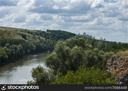 Countryside natural panoramic landscape with river and hills on clear summer sunny day